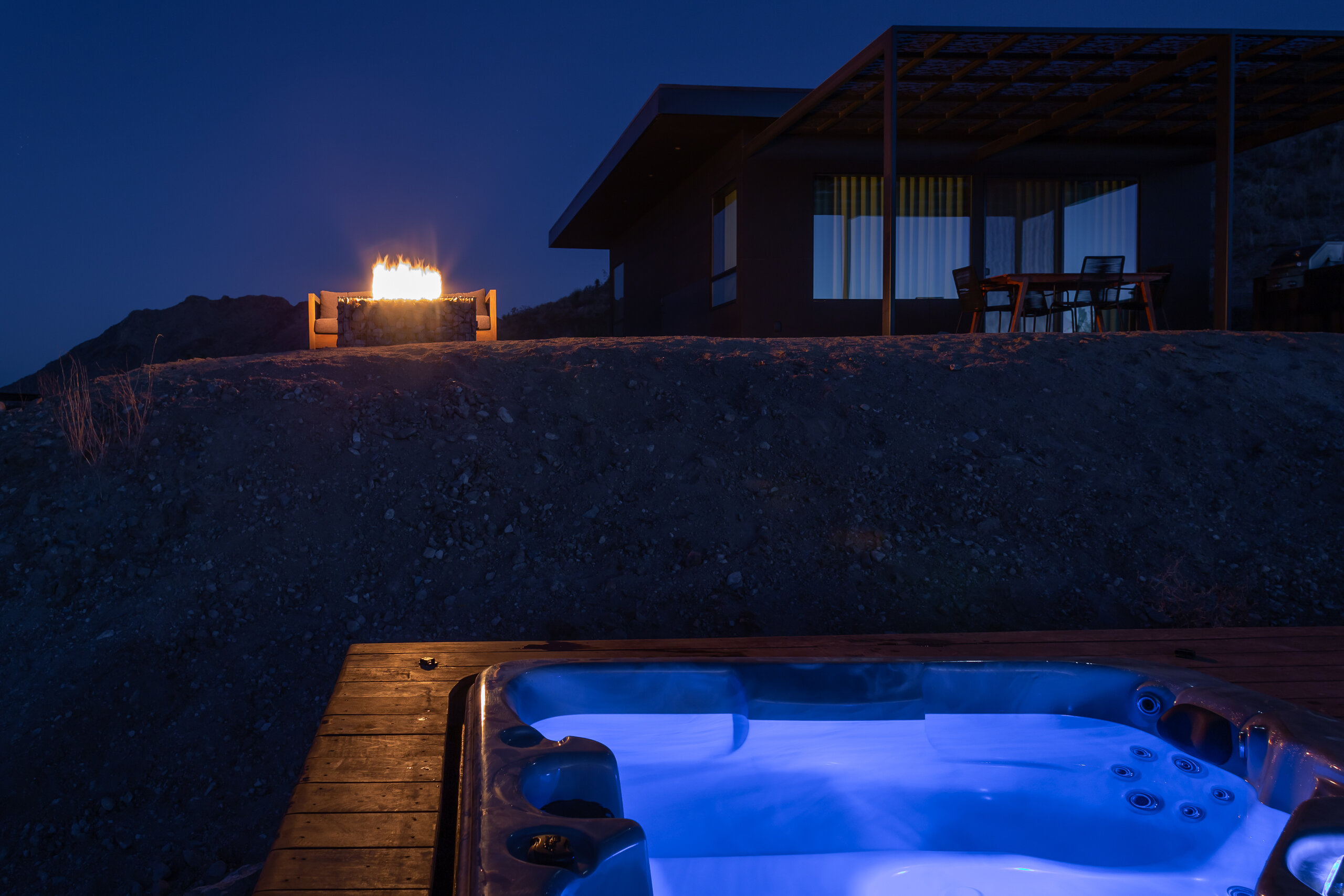 Fire pit and hot tub below Pause House PM at dusk
