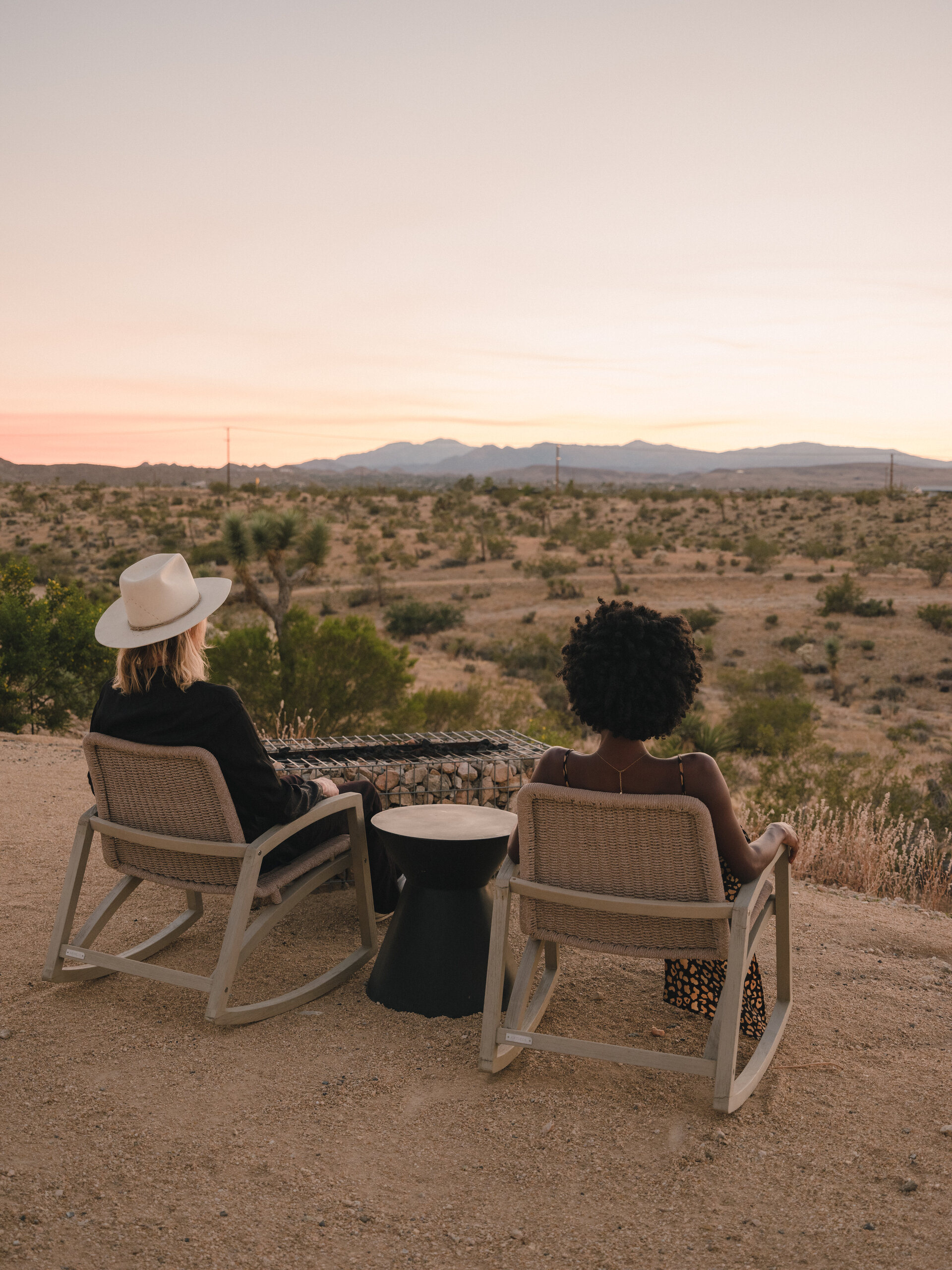 Two rocking chairs facing the sunset at Pause House